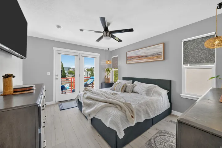 Bedroom featuring wood-finish flooring, a ceiling fan, and direct access to an outdoor patio through double French doors