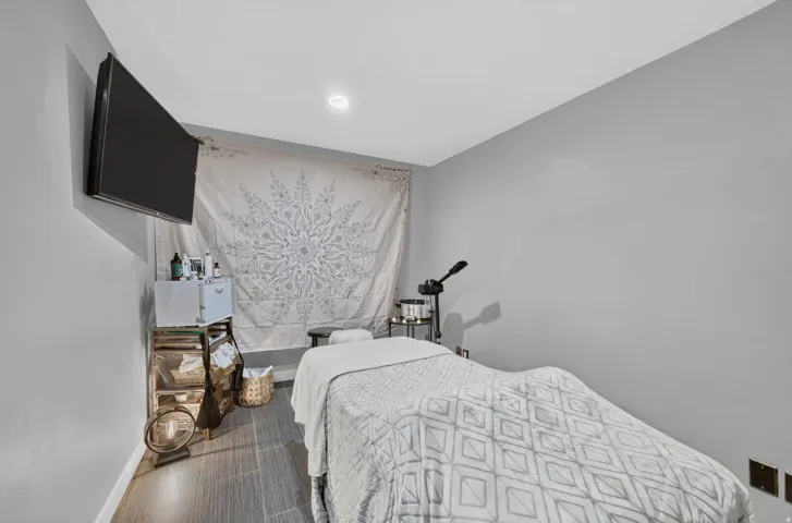 Recessed lighting illuminates this room featuring gray walls and wood-finish flooring