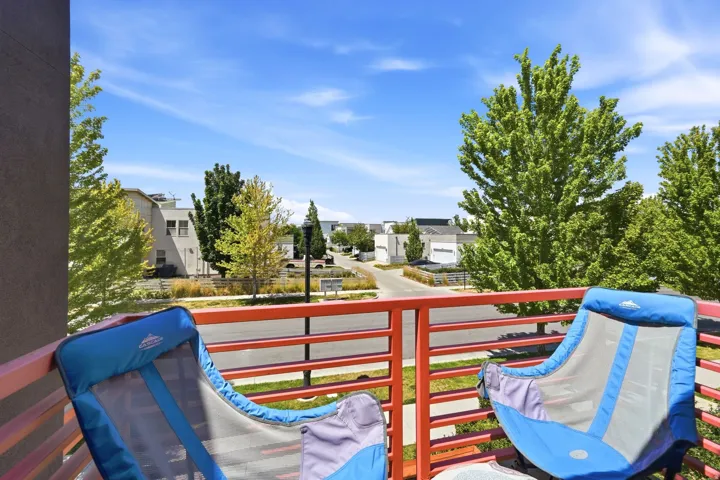 Upper-level balcony featuring red horizontal railings and composite siding