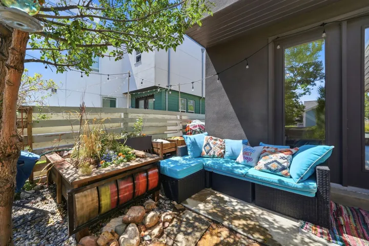Private patio featuring a built-in planter, gravel and rock hardscaping, and a substantial tree providing natural shade