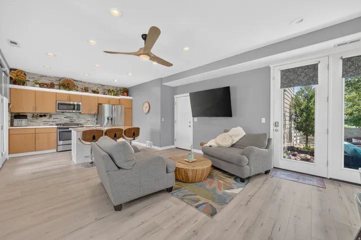 Open-concept living space featuring wood-finish flooring, recessed lighting, and a modern ceiling fan