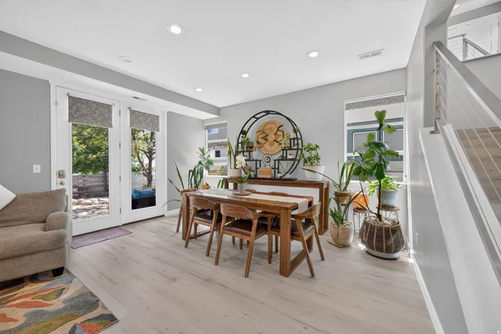 Open-concept living area with light wood-finish flooring, recessed ceiling lighting, and light gray wall tones