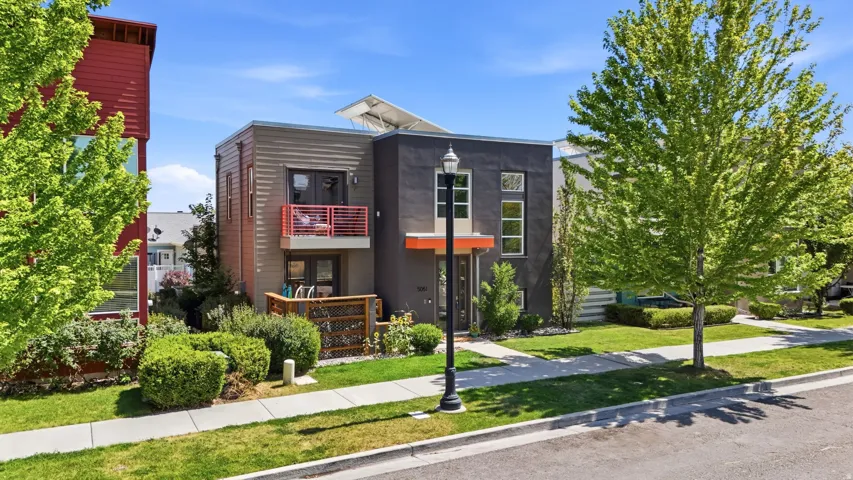 Modern multi-level residence featuring a contemporary facade with varied siding materials and an orange accent entrance