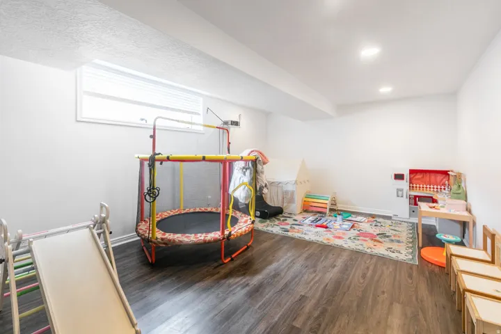 Finished basement  rec room with wood-finish flooring and recessed lighting,  Not shown are three additional bedrooms down.