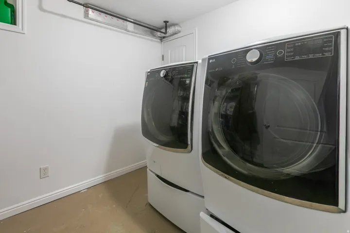 Dedicated laundry area with durable flooring, white walls, and baseboard trim