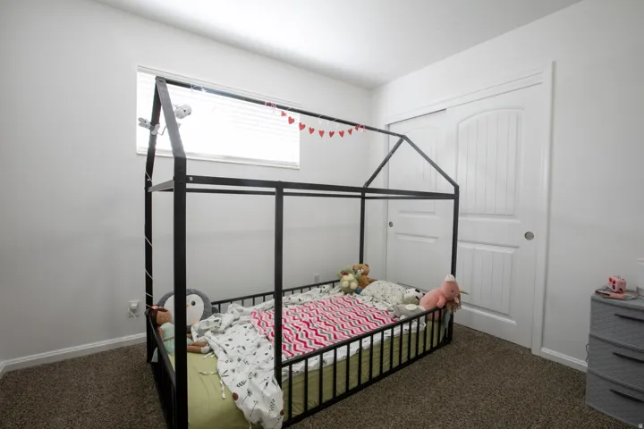 Bedroom featuring plush carpet, white walls, and window.