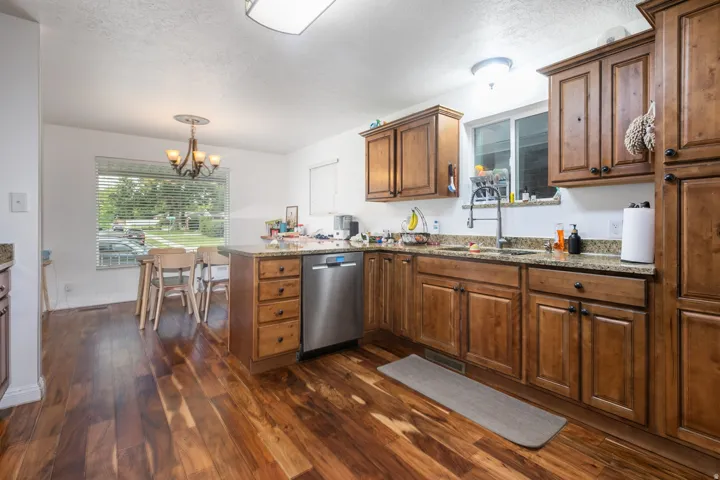 Updated kitchen with wood-finish flooring, wood cabinetry, granite countertops, stainless steel appliances.
