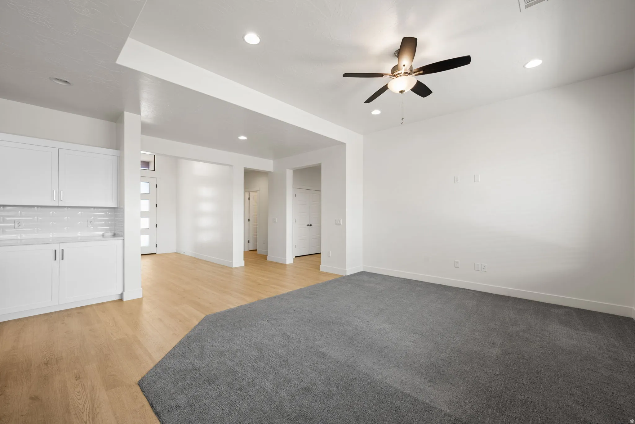 Open-concept living area featuring a neutral color palette, recessed lighting, and a ceiling fan