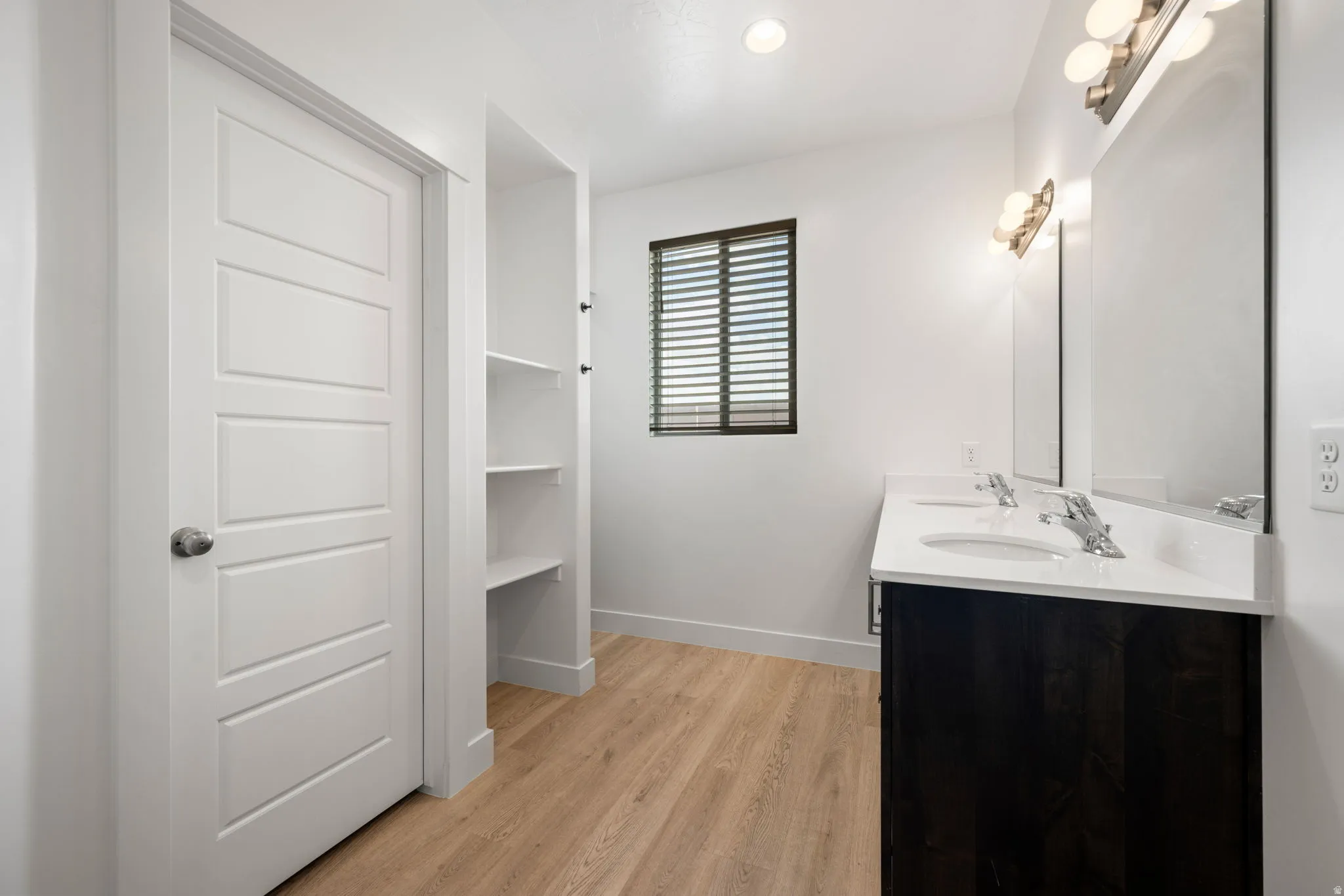 Dual vanity with white countertop and dark wood-finish cabinetry