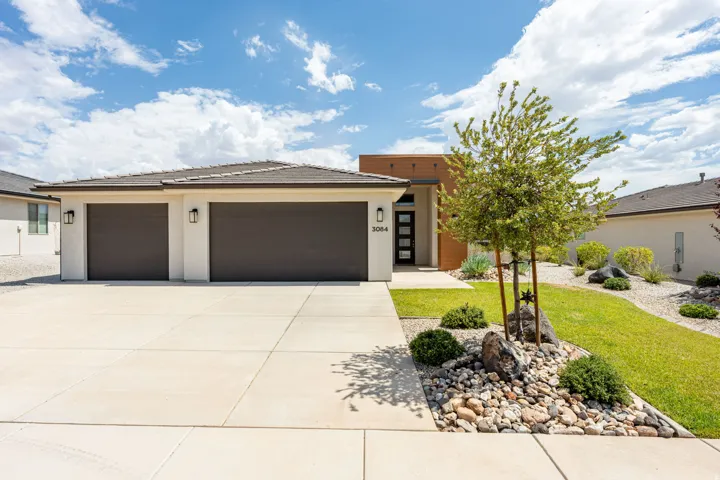 Contemporary single-story residence featuring a two-car garage with dark brown doors and exterior sconces