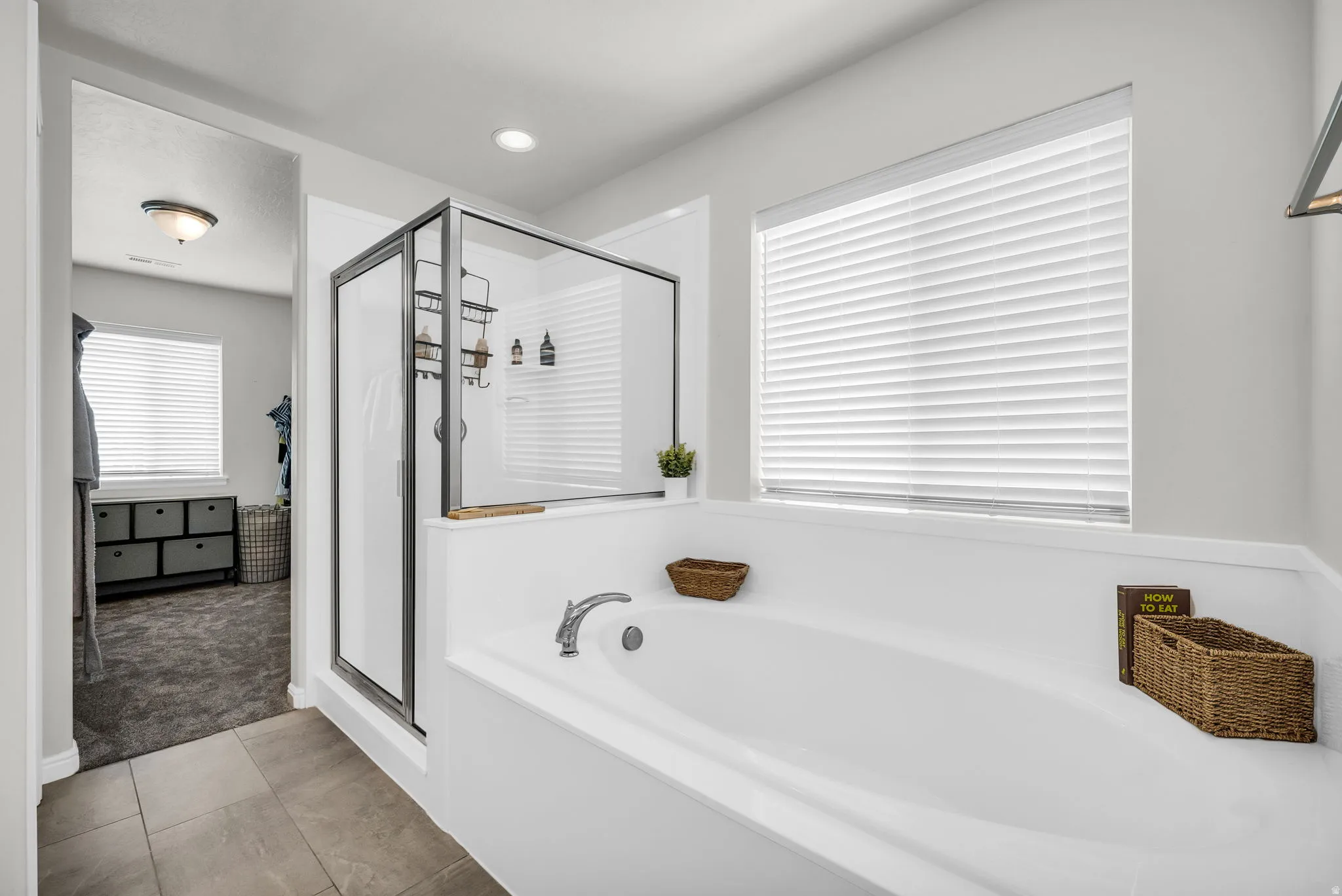 Soaking tub with deck-mounted faucet and adjacent glass-enclosed shower