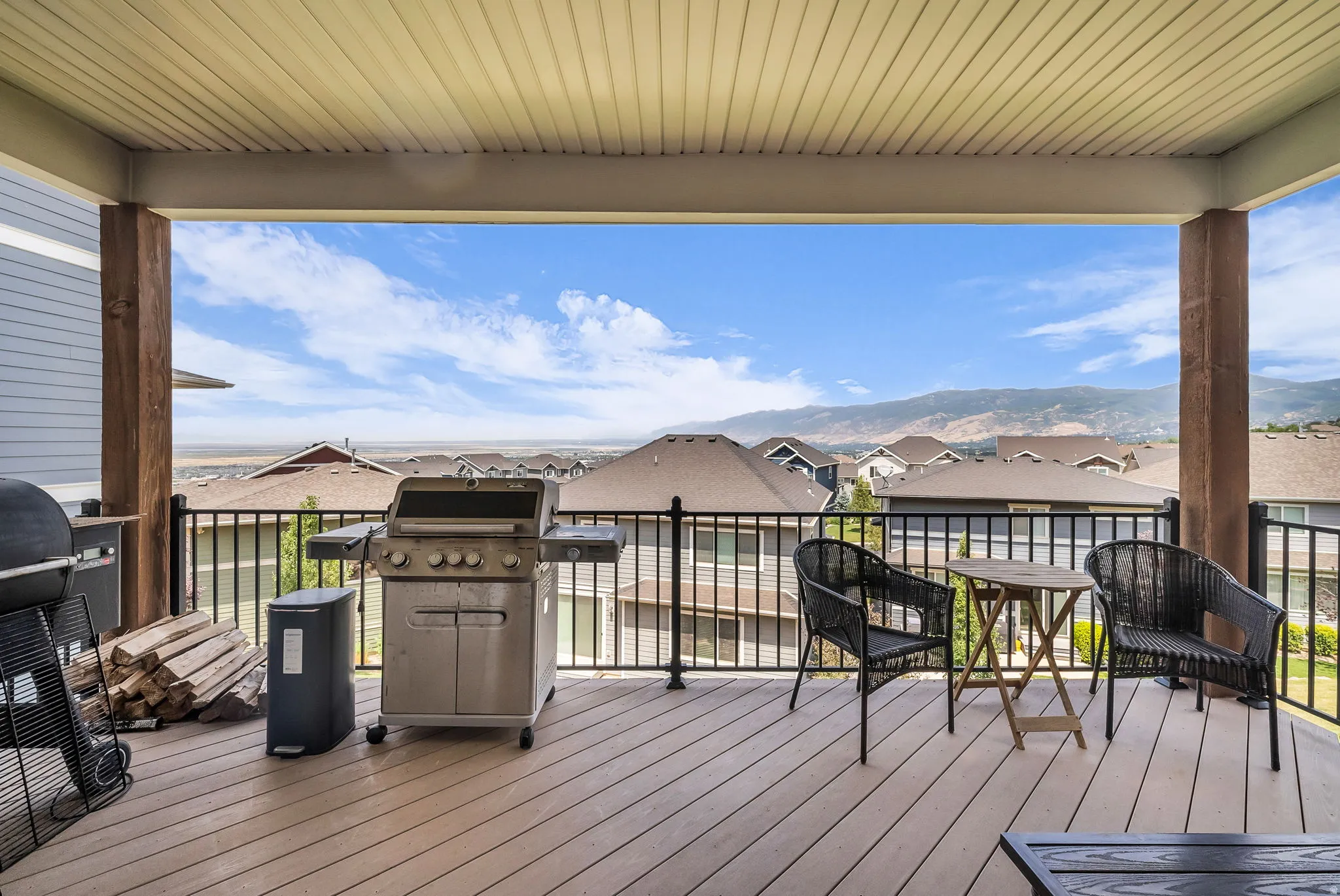 Covered outdoor deck with composite flooring and black metal railing