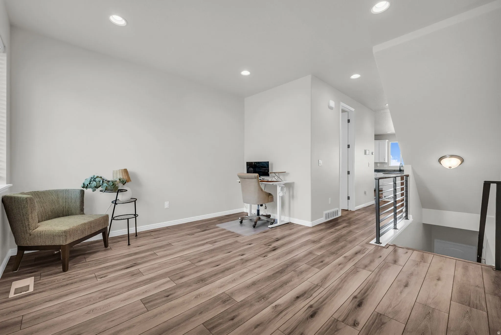Spacious room featuring wood-finish flooring, recessed lighting, and a neutral color palette