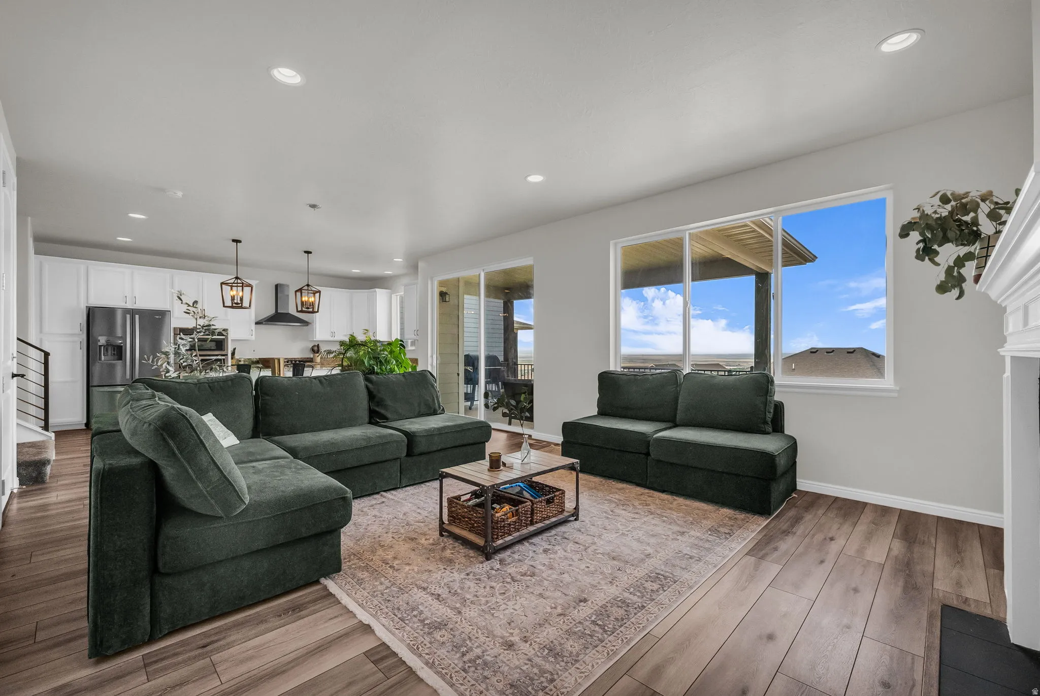 Spacious living area featuring wood-finish flooring and a white-mantled fireplace