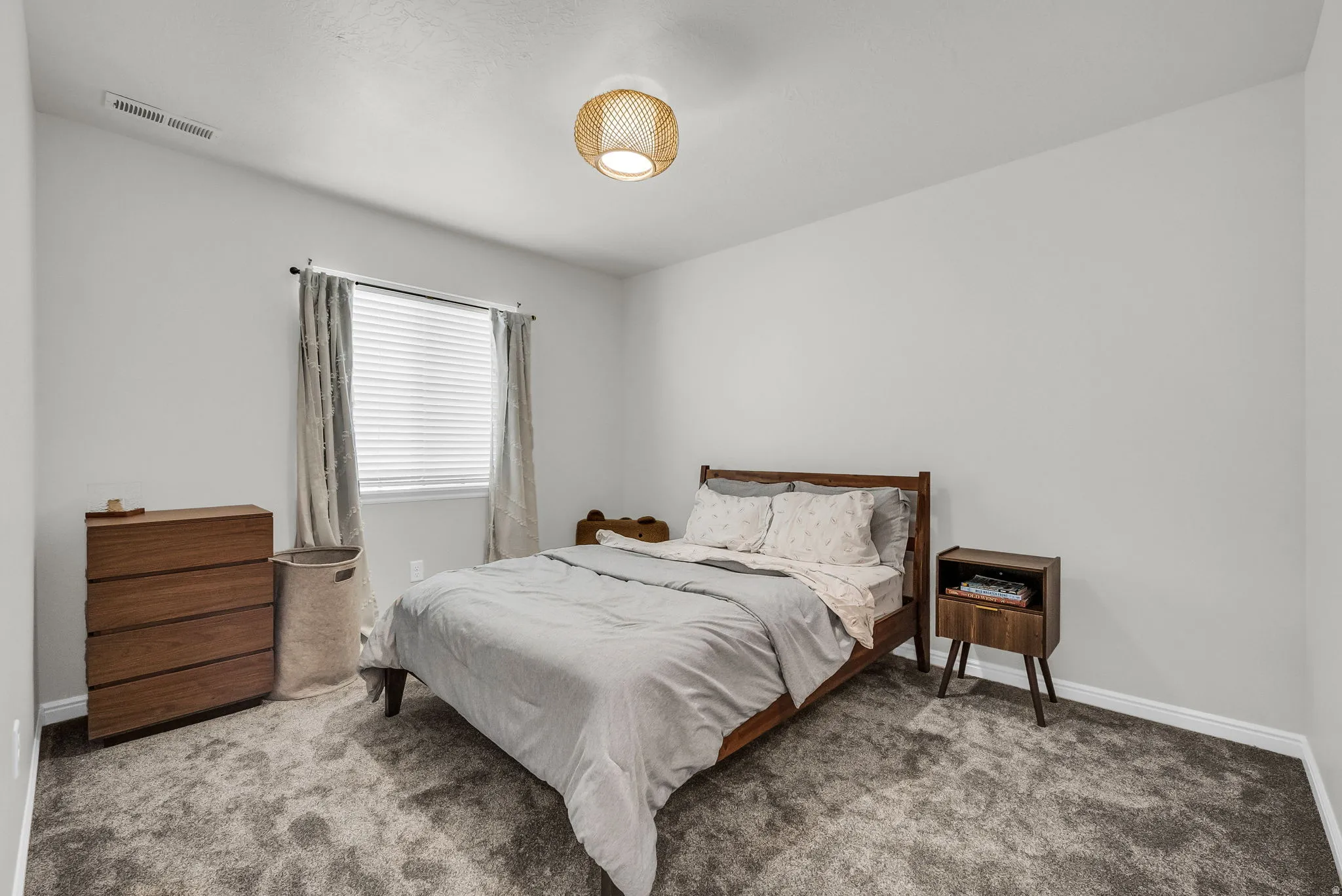 Interior room featuring textured carpeting, white baseboards, and neutral wall tones