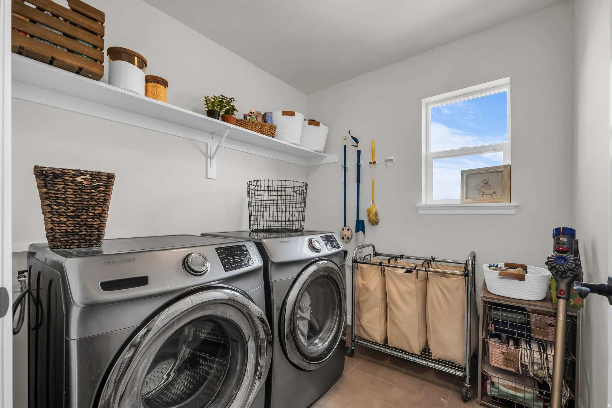Dedicated laundry area featuring a single window, two wall-mounted shelves, and light-toned wall paint