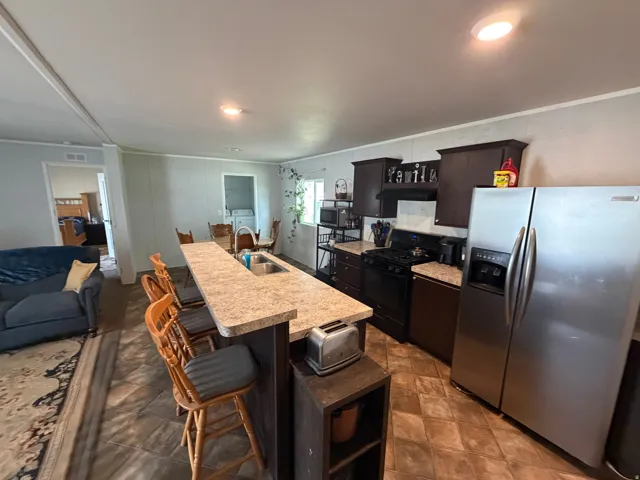 Kitchen featuring a peninsula with integrated sink and breakfast bar seating