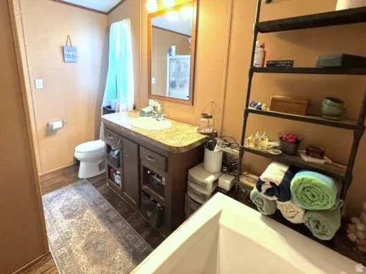 Bathroom featuring wood-finish flooring and wall paneling