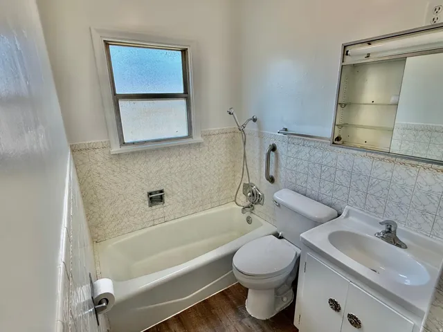 Bathroom featuring a white bathtub, white toilet, and a white vanity with an integrated sink