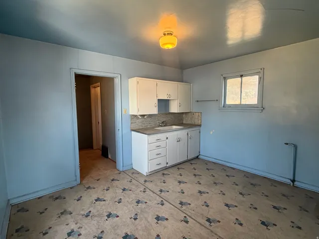 Kitchen area featuring built-in cabinetry, a countertop with integrated sink, and an overhead light fixture