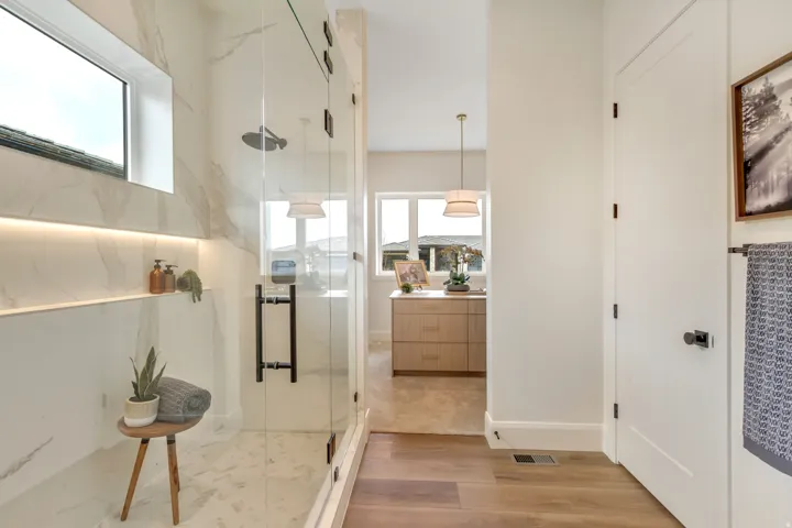 Contemporary shower with glass enclosure, dual shower heads, integrated niche shelving with accent lighting, and a horizontal window