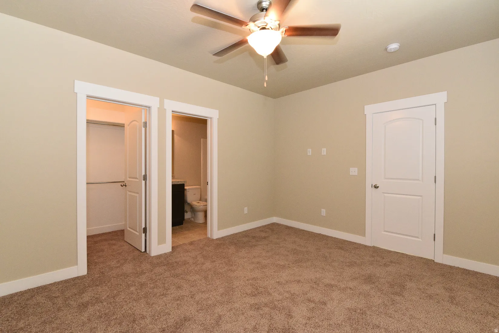 Carpeted room featuring a ceiling fan with integrated lighting