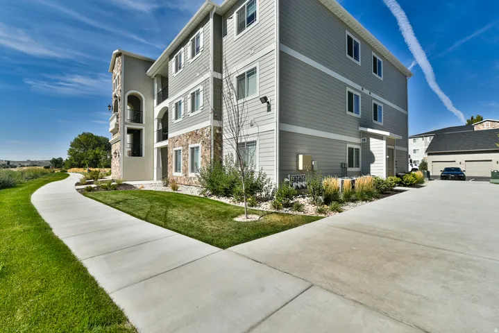Modern multi-story building featuring light gray siding and stone facade accents