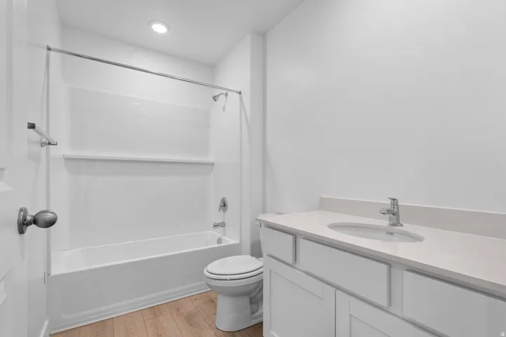 Bathroom featuring a single vanity with light-toned countertop, integrated sink, and chrome faucet