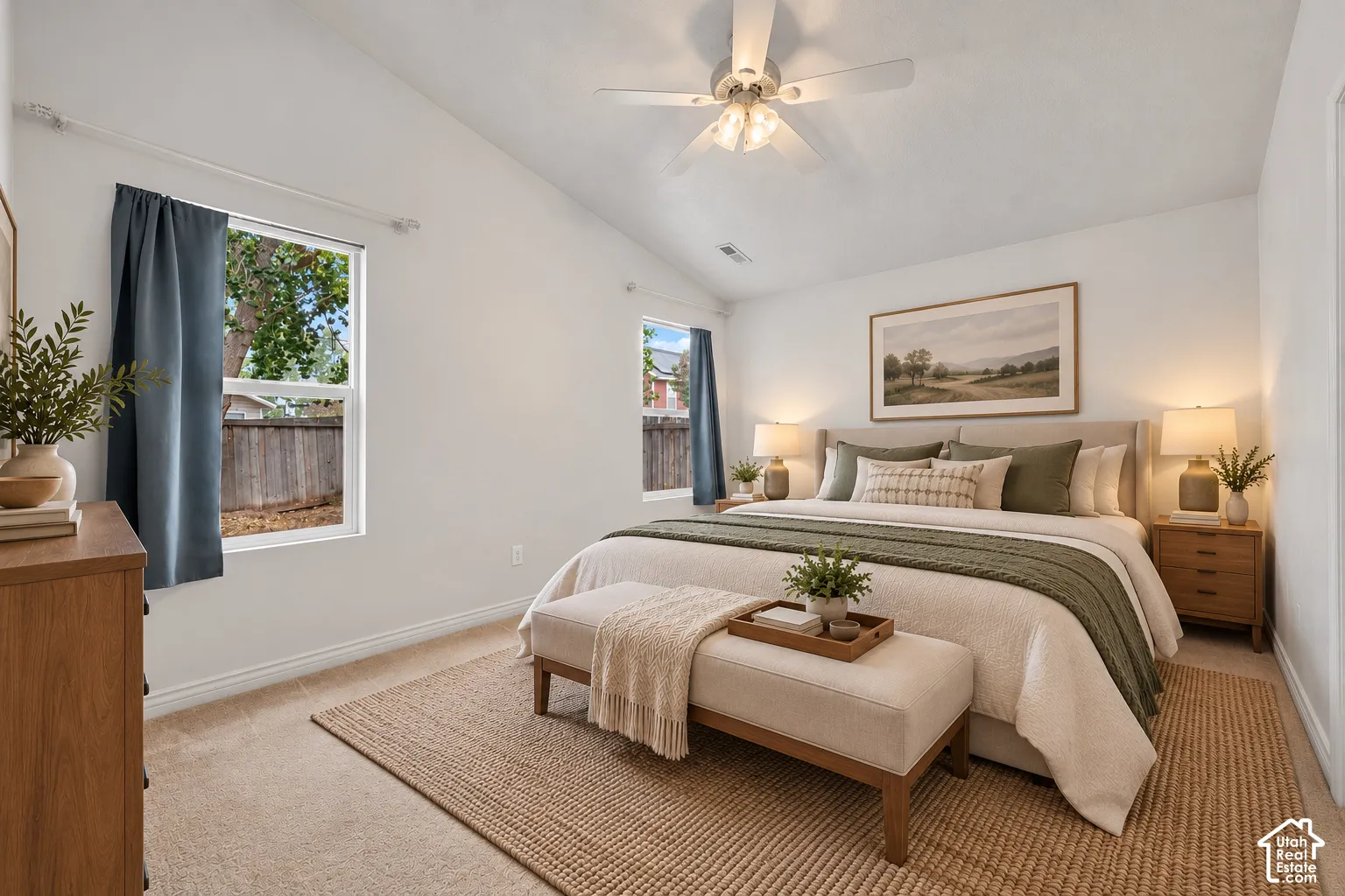 Primary Suite with vaulted ceilings, neutral carpeting, and a ceiling-mounted light fixture with a fan. Virtually Staged.