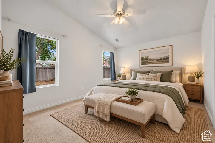 Primary Suite with vaulted ceilings, neutral carpeting, and a ceiling-mounted light fixture with a fan. Virtually Staged.