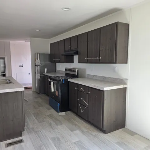 Kitchen featuring wood-finish cabinetry, light-toned countertops, and light wood-finish flooring