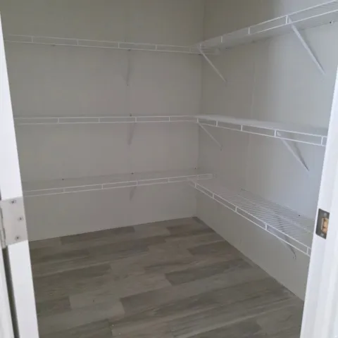 Walk-in pantry featuring white wire shelving on multiple walls, providing extensive storage options