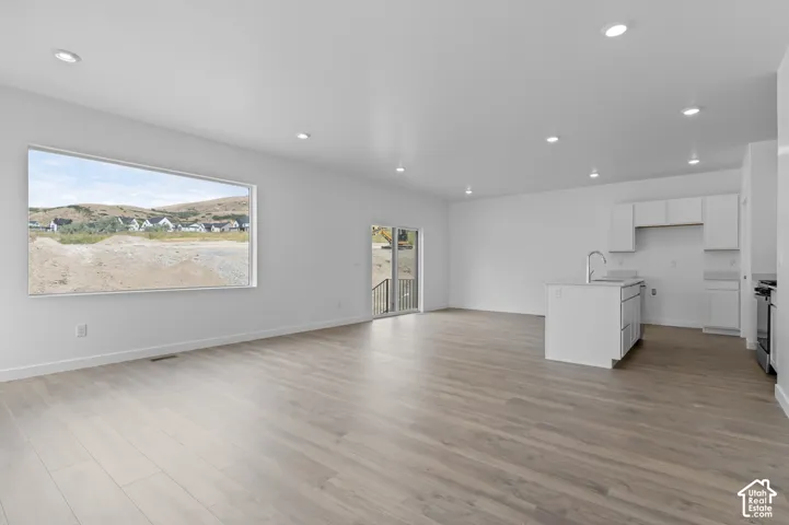 Open concept living space featuring wood-finish flooring and recessed lighting