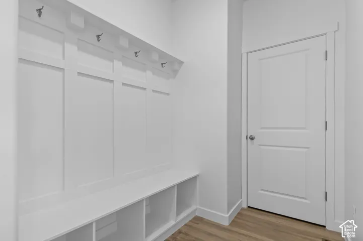 Built-in mudroom bench with cubby storage and paneling featuring five coat hooks