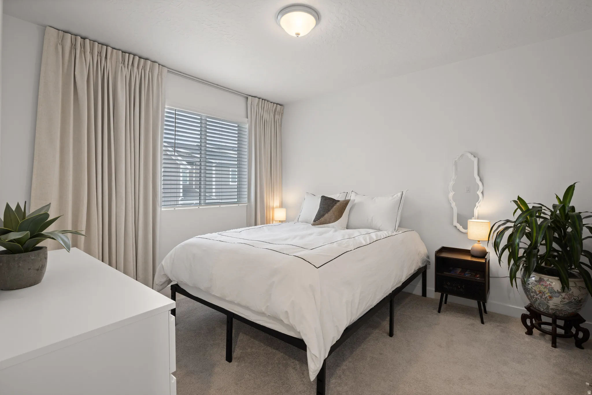 Bedroom 3 featuring neutral wall paint, carpet flooring, a window with horizontal blinds, and full-height drapery