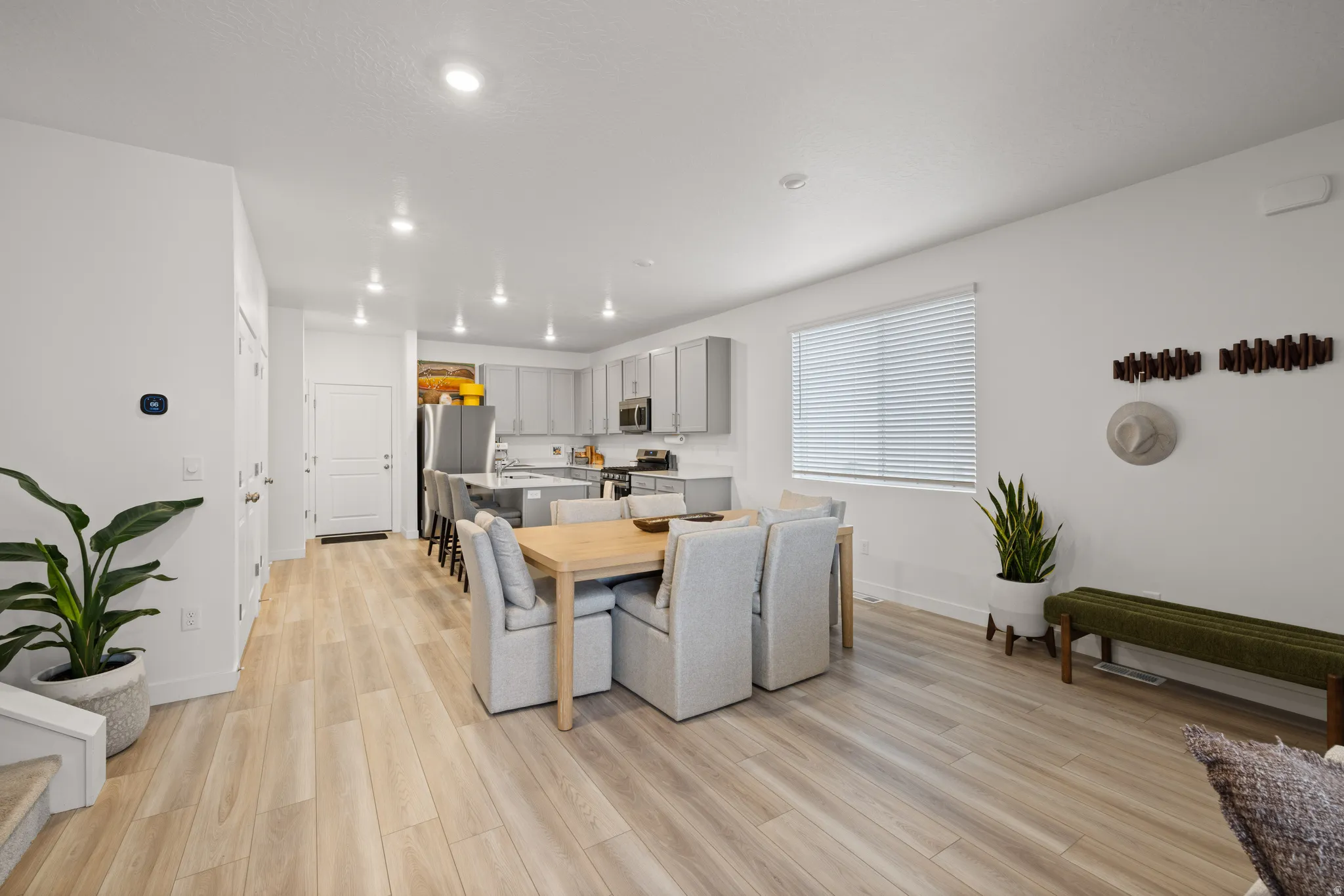 Open-concept living space featuring wood-finish flooring, recessed lighting, and a modern kitchen