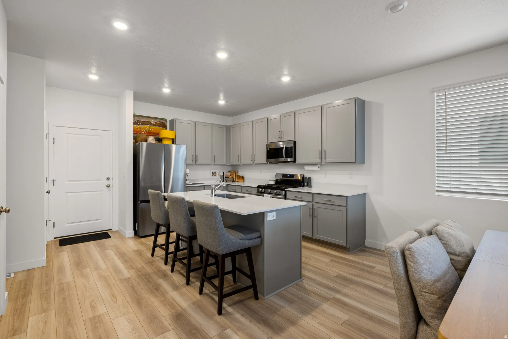 Modern kitchen featuring light gray cabinetry and stainless steel appliances