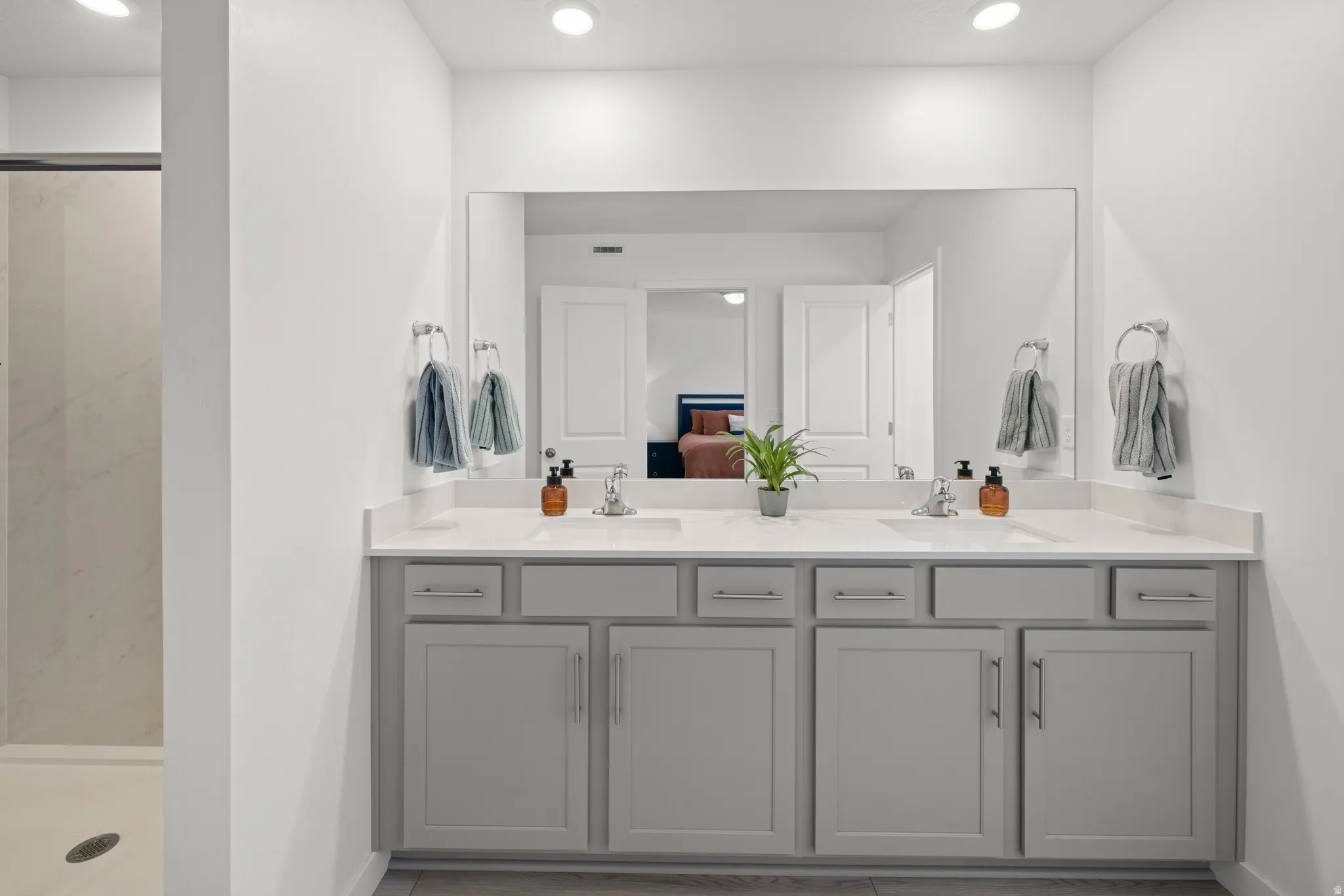 Master bath Double vanity with light gray cabinetry, integrated sinks, and polished chrome fixtures