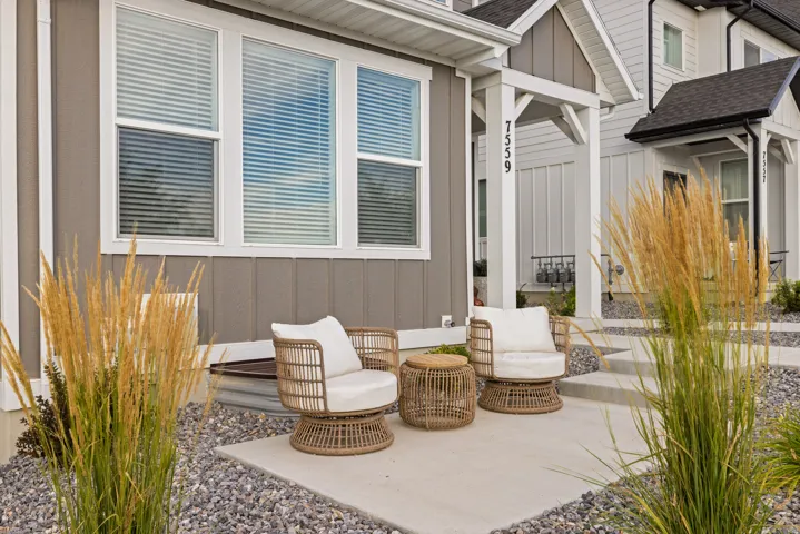 Exterior featuring a concrete patio, gravel landscaping, and decorative grasses