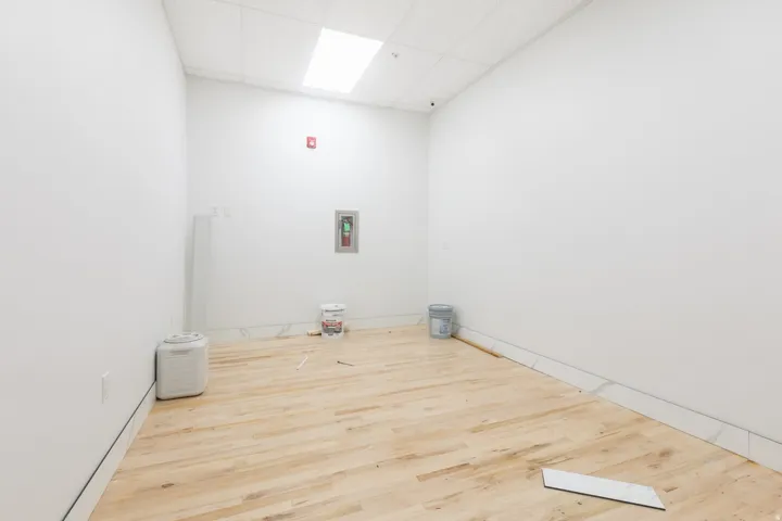 Light wood-finish flooring with white baseboards