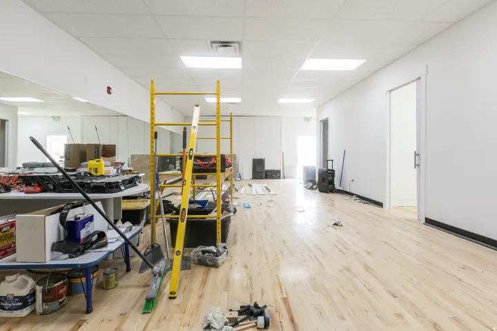 Spacious interior featuring wood-finish flooring, white walls, and a drop ceiling with recessed lighting