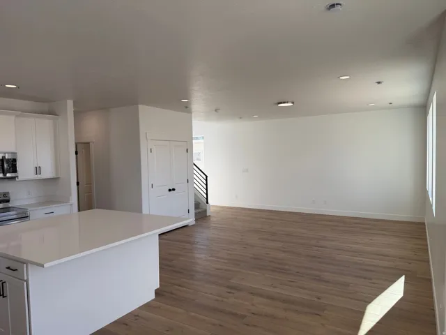 Open concept living area featuring wood-finish flooring, recessed lighting, and white walls