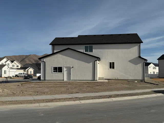 Contemporary stucco exterior with a black shingle roof