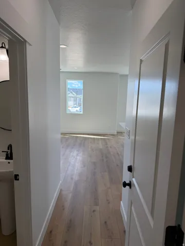 Open-concept room featuring wood-finish flooring, white walls, and a recessed lighting system