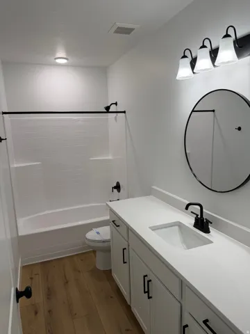 Bathroom featuring a white vanity with a rectangular integrated sink, matte black faucet, and white countertop
