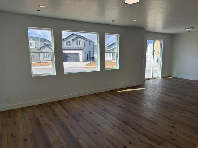 Spacious interior featuring wood-finish flooring, white walls, and recessed lighting