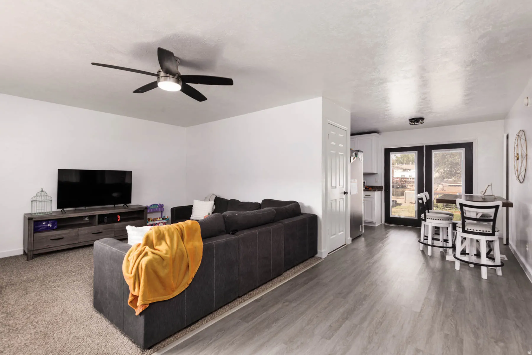 Open-concept living space featuring wood-finish flooring, a contemporary ceiling fan, and recessed lighting