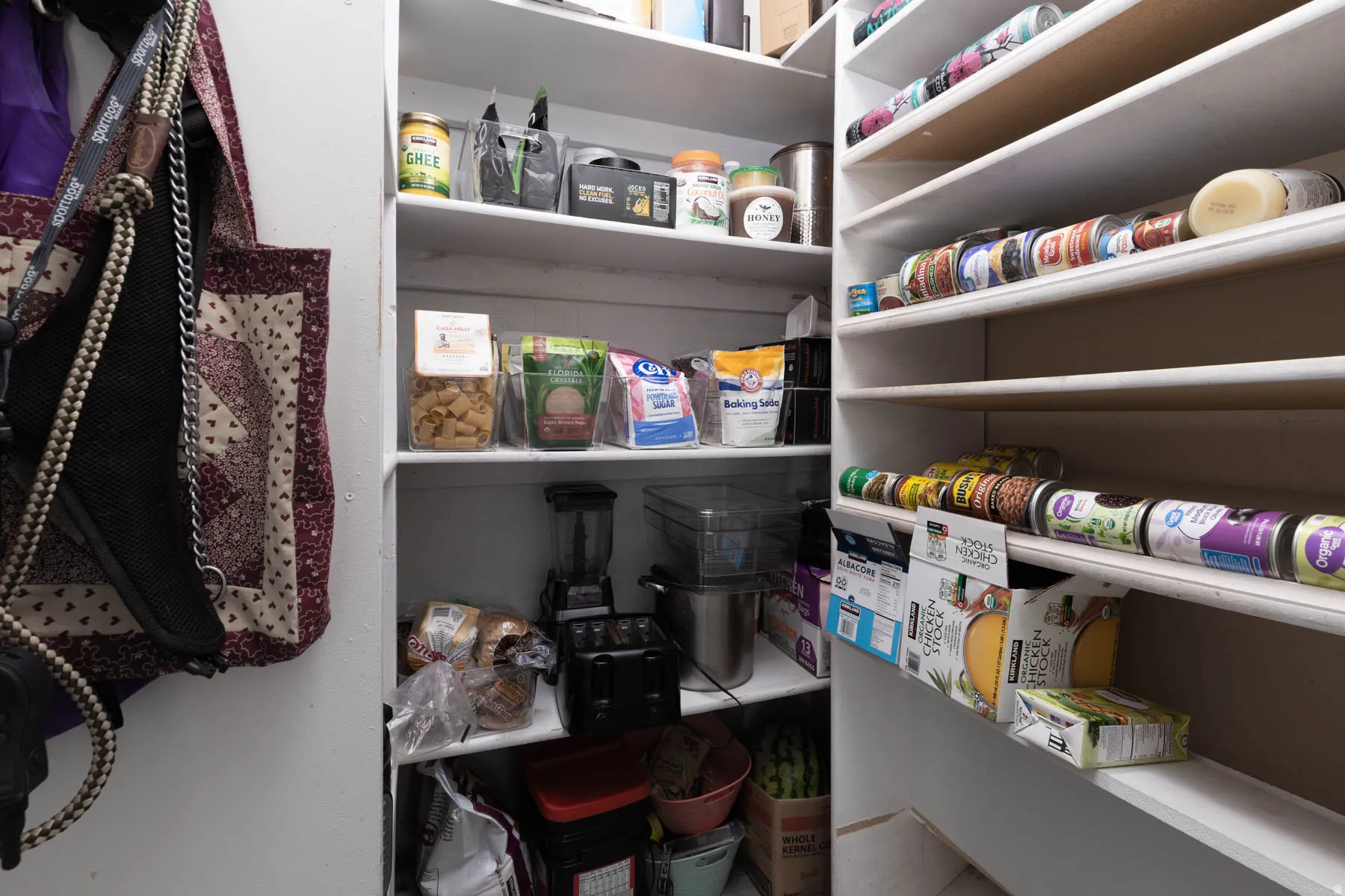 Spacious walk-in pantry featuring multiple levels of shelving