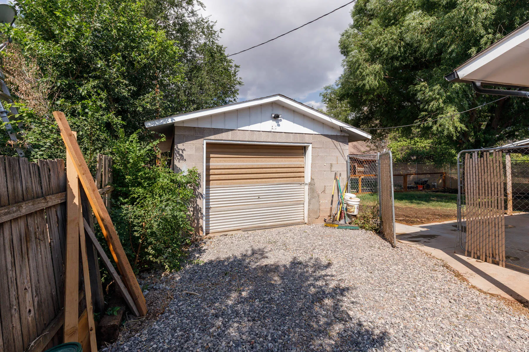 Detached garage with a roll-up door, cinder block construction, and a peaked roof