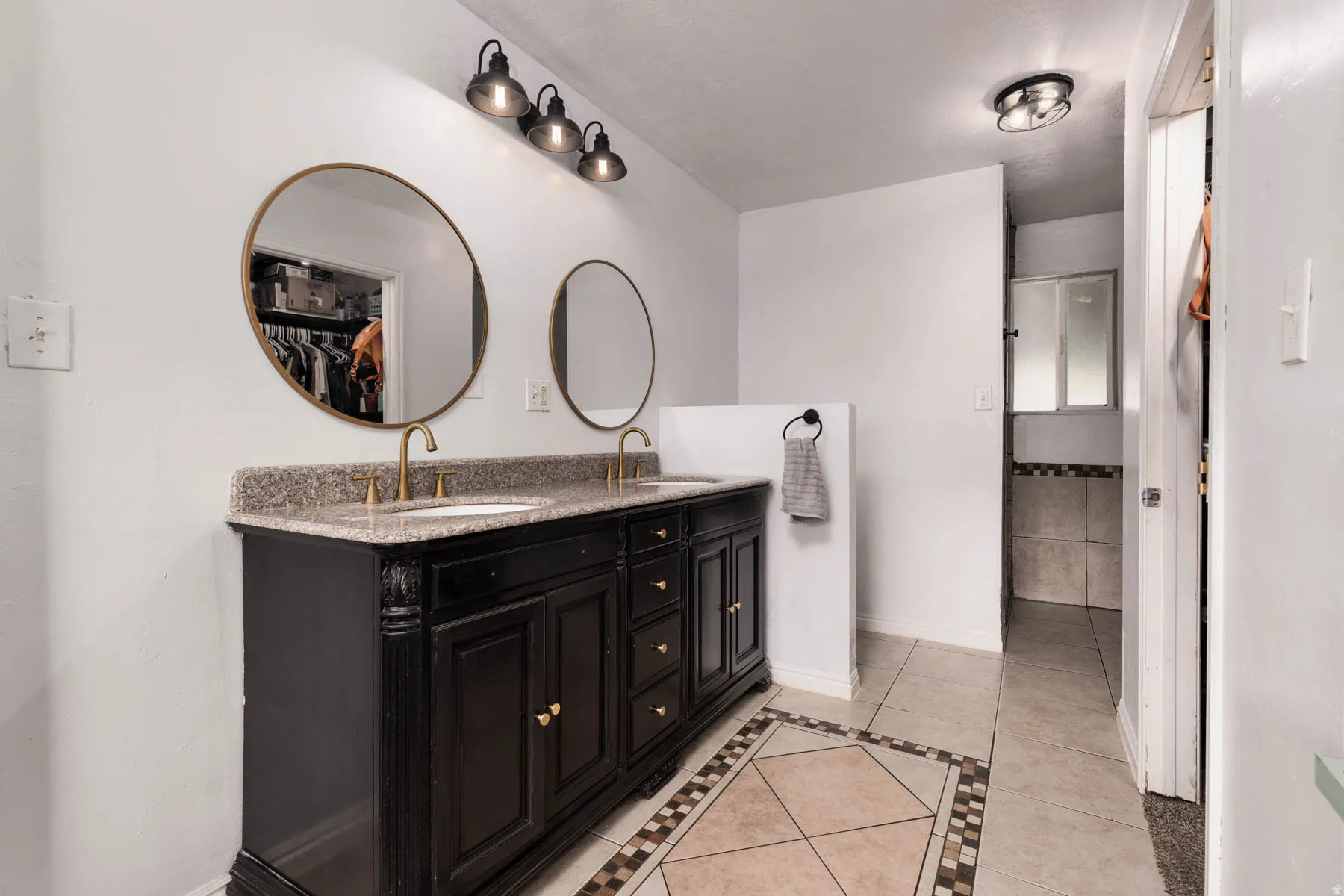 Double vanity with a granite countertop, dual undermount sinks, and brass fixtures
